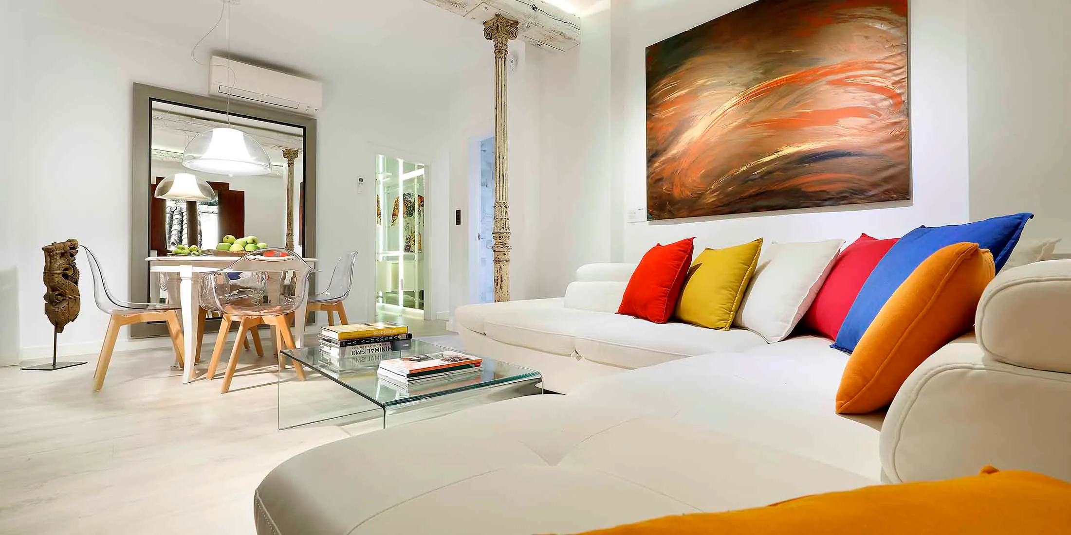 Salon lumineux d'un appartement meublé avec canapé blanc et table basse