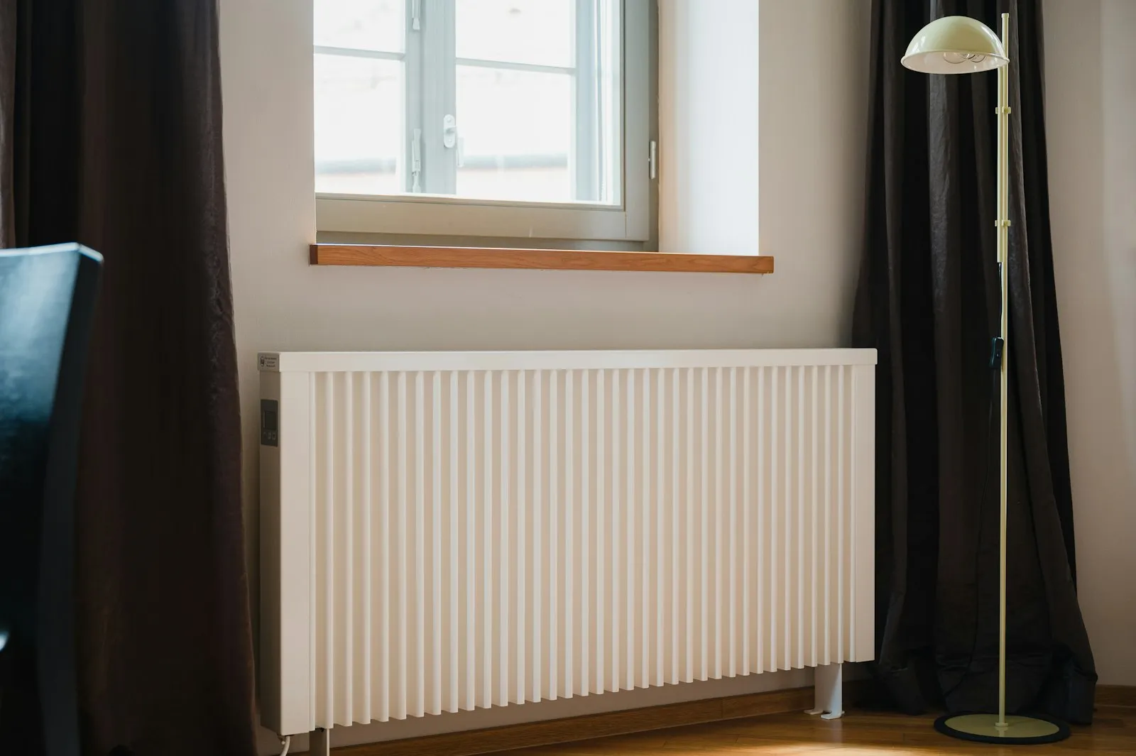 Radiateur électrique blanc sous une fenêtre dans un appartement lumineux
